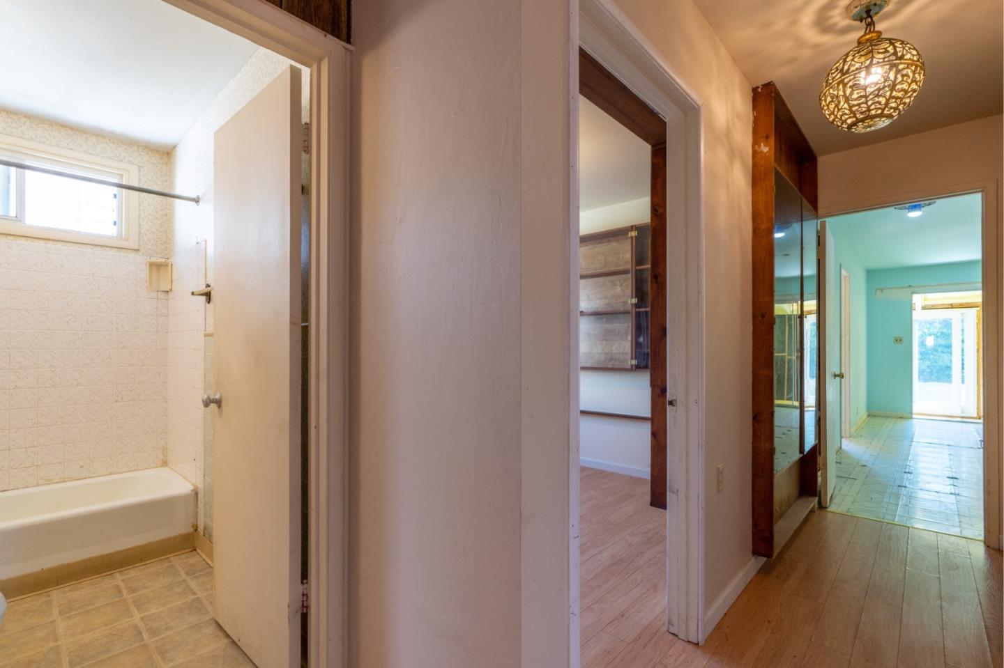 1139 Peralta Road Pacifica, CA 94044 - Photo 15 of 23 a view of a hallway with wooden floor and a bathroom