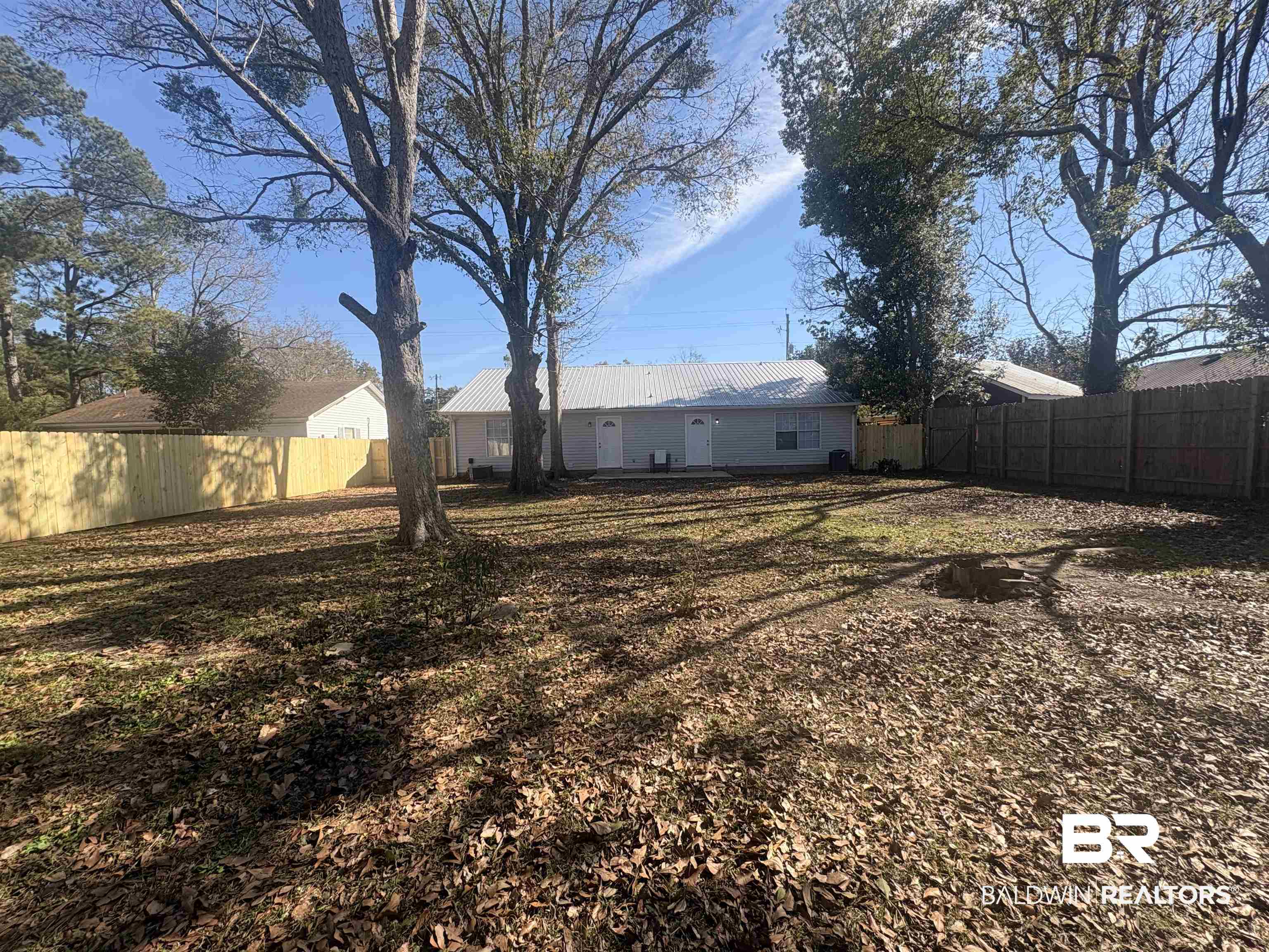 109-111 North Beech Street, Unit A & B Foley, AL 36535 - Photo 12 of 16 Rear view of property with a fenced backyard and a metal roof