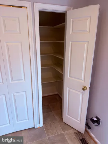 a view of walk in closet with empty racks