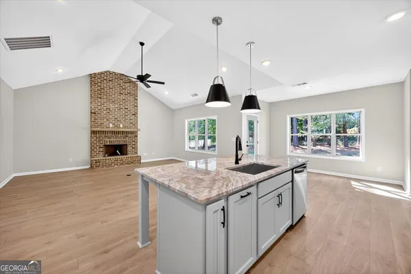 a kitchen with granite countertop a sink a counter space and stainless steel appliances