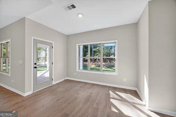 an empty room with closet and windows