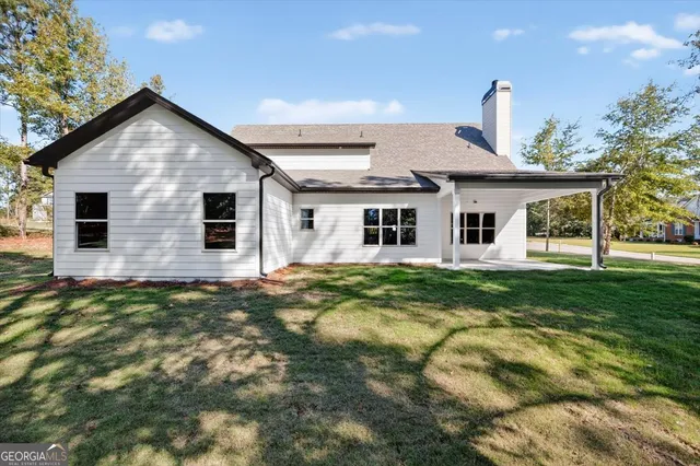 a view of a house with a yard patio and swimming pool