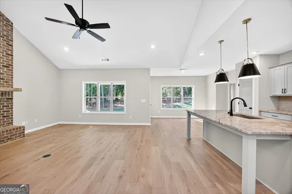 a kitchen with a sink chandelier and wooden floor