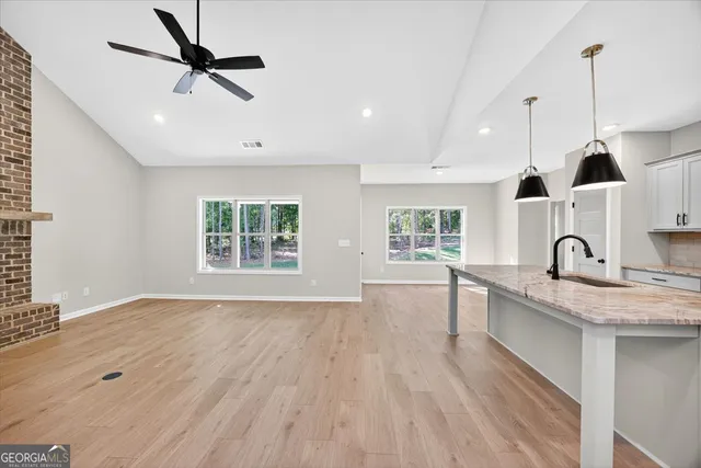 a kitchen with a sink chandelier and wooden floor