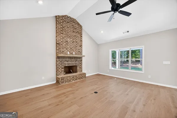 a large kitchen with stainless steel appliances kitchen island a large counter top and a fireplace