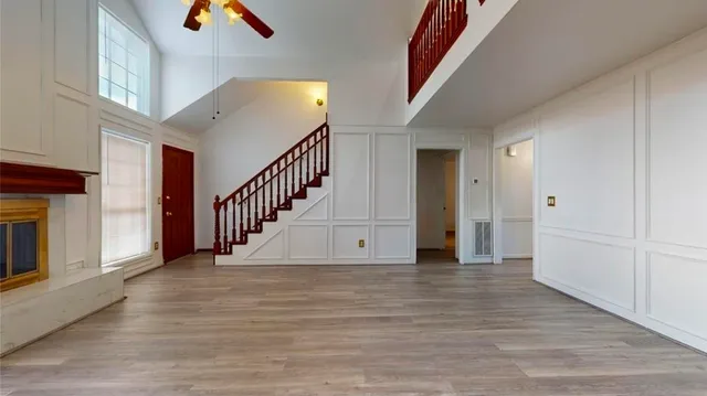 a view of a hallway with wooden floor and staircase