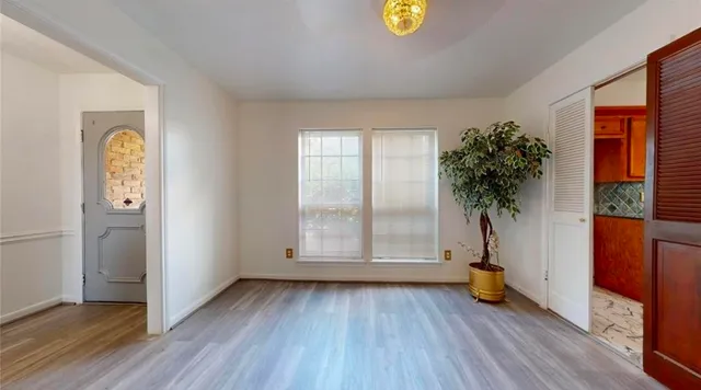 an empty room with windows and wooden floor