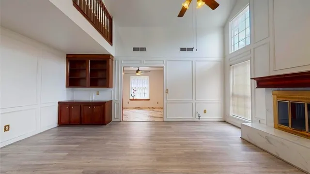 a view of an empty room with window and wooden floor
