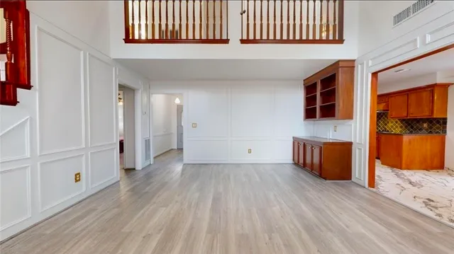 a view of a hallway with wooden floor and a bathroom