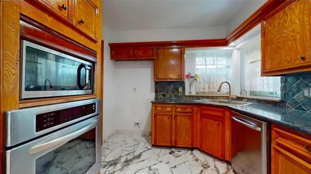 a kitchen with stainless steel appliances granite countertop a sink stove and cabinets