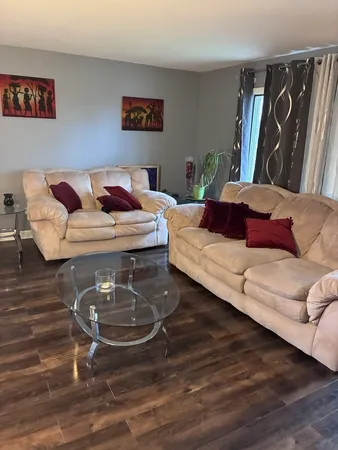 a living room with furniture and wooden floor