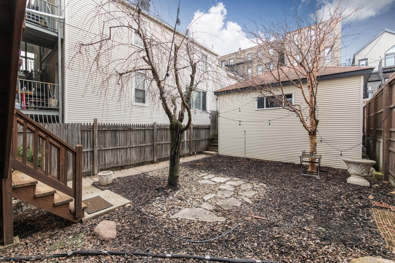 1249 North Cleaver Street, Unit G Chicago, IL 60642 - Photo 18 of 21 a view of a house with a small yard and wooden fence