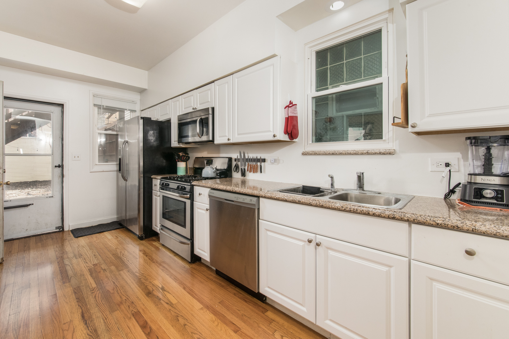 1249 North Cleaver Street, Unit G Chicago, IL 60642 - Photo 9 of 21 a kitchen with granite countertop stainless steel appliances a sink and cabinets