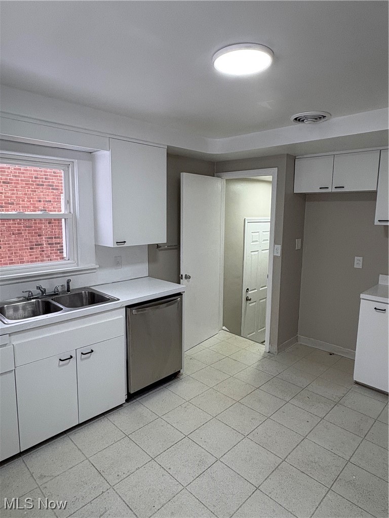 Kitchen with white cabinetry, light countertops, and dishwasher
