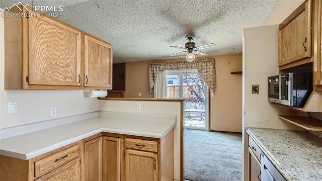 5266 Pinon Valley Road Colorado Springs, CO 80919 - Photo 10 of 22 Kitchen looking back into Dining Room and to Back Yard