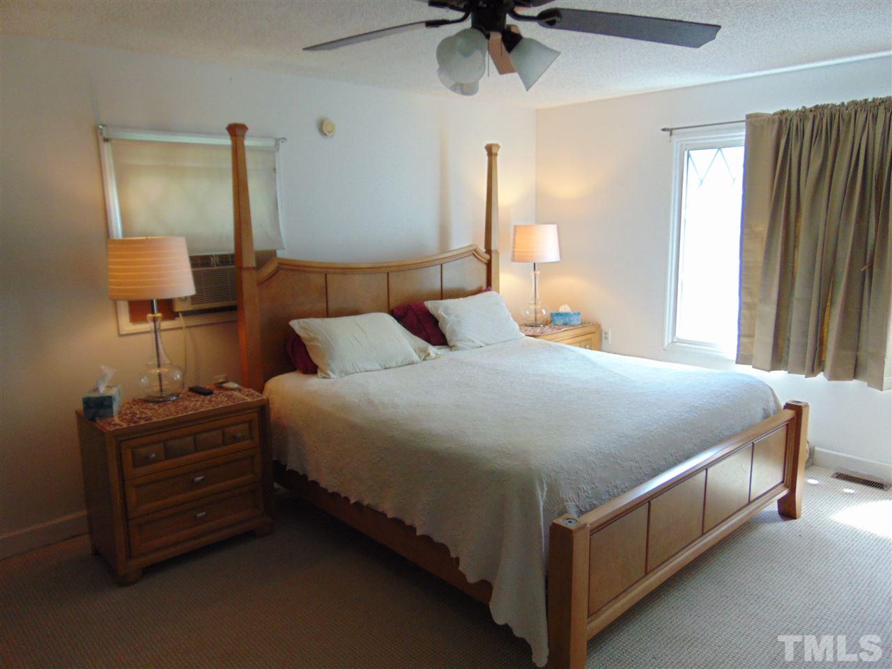 2068 Sanders Road Stem, NC 27581 - Photo 12 of 21 a bed room with a bed and a lamp