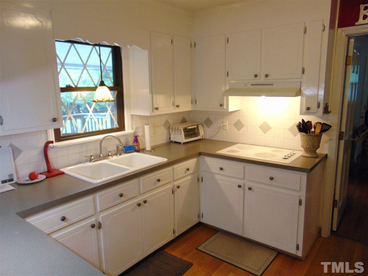 2068 Sanders Road Stem, NC 27581 - Photo 8 of 21 a kitchen with a sink window and cabinets