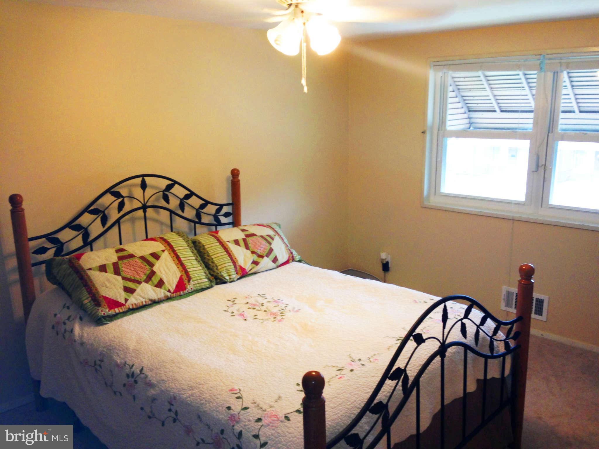 1011 Bayner Road Baltimore, MD 21221 - Photo 13 of 30 a bedroom with a bed a dresser and window