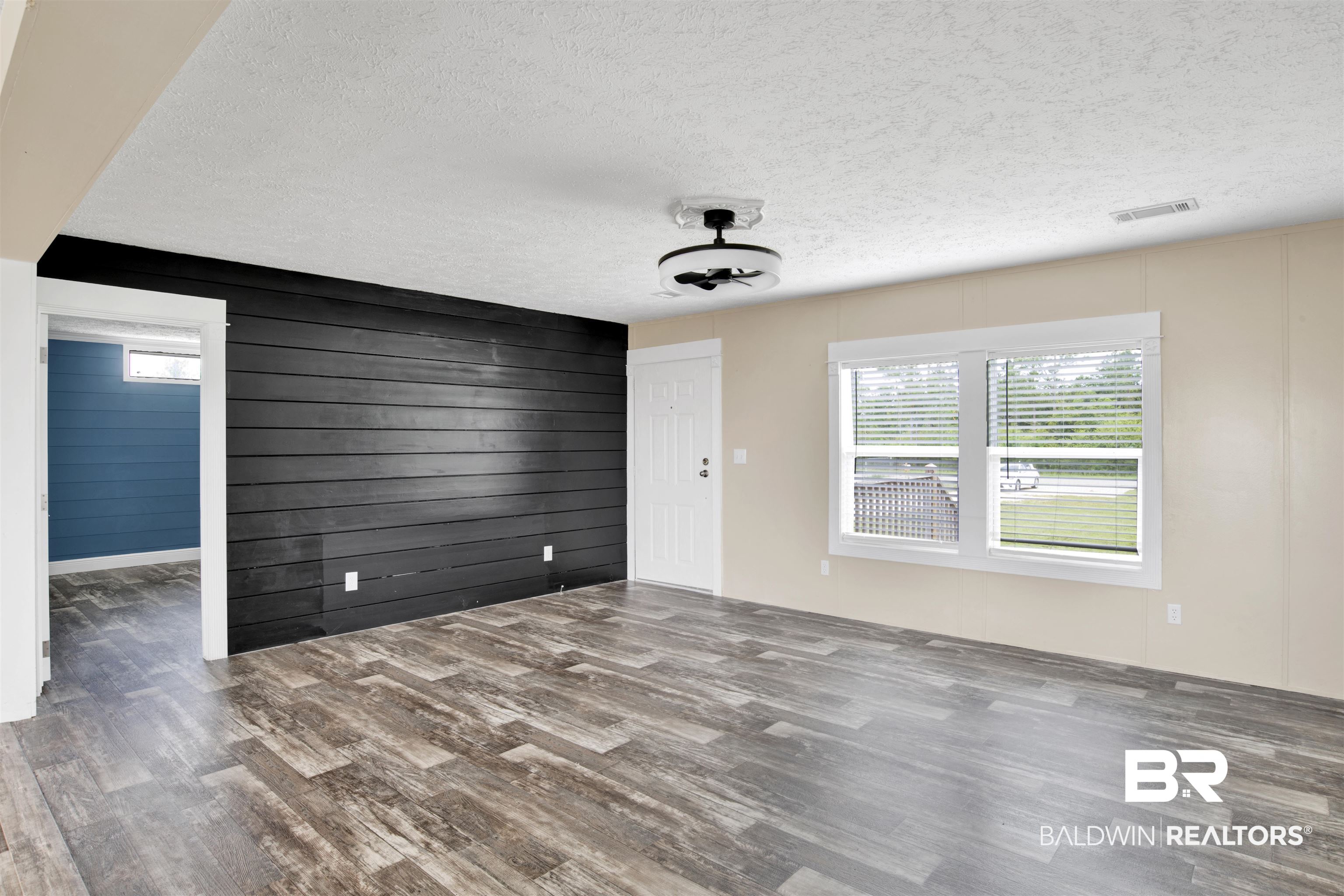 16778 County Road 87 Elberta, AL 36530 - Photo 11 of 32 Spare room featuring a textured ceiling, wood-type flooring, and wooden walls