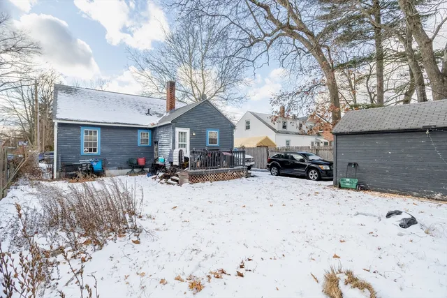 a view of a white house with a yard covered in snow