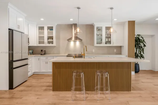 a kitchen with kitchen island a sink stainless steel appliances and cabinets