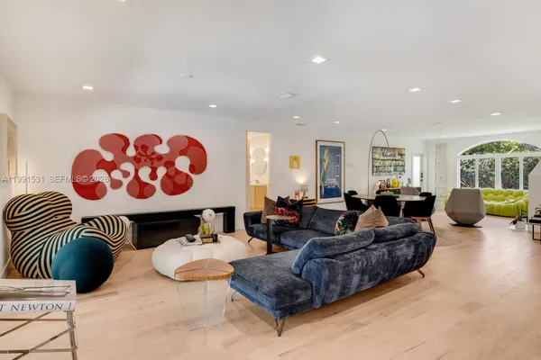 a living room with furniture a flat screen tv and a large window