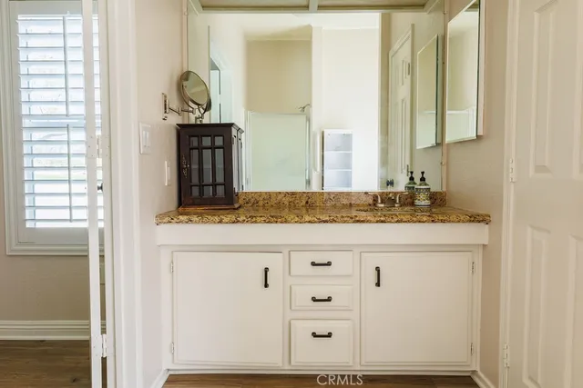a bathroom with a granite countertop sink and a mirror