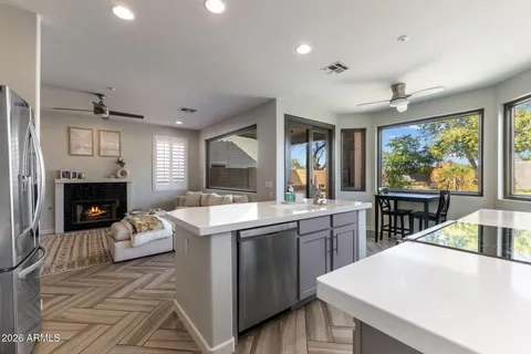 a kitchen with a stove a sink a dining table and chairs with wooden floor