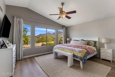 a bedroom with a bed and a flat tv screen on dresser