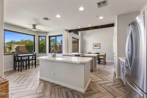 a open kitchen with stainless steel appliances granite countertop a refrigerator a sink a stove and island with wooden floor