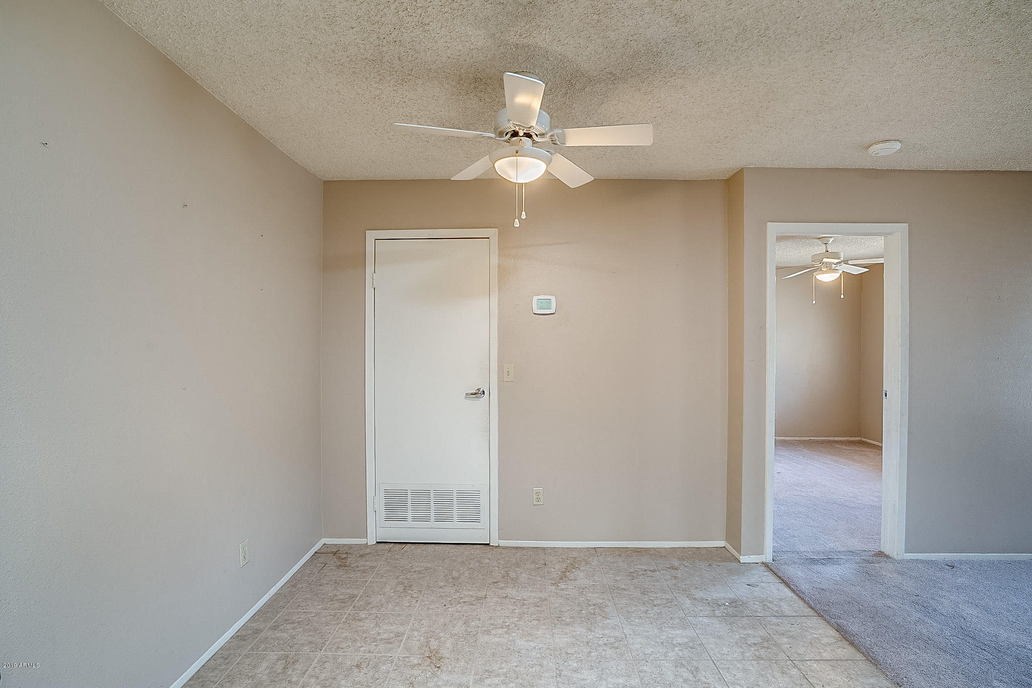 3511 East Baseline Road, Unit 1122 Phoenix, AZ 85042 - Photo 7 of 21 an empty room with an entryway and fan