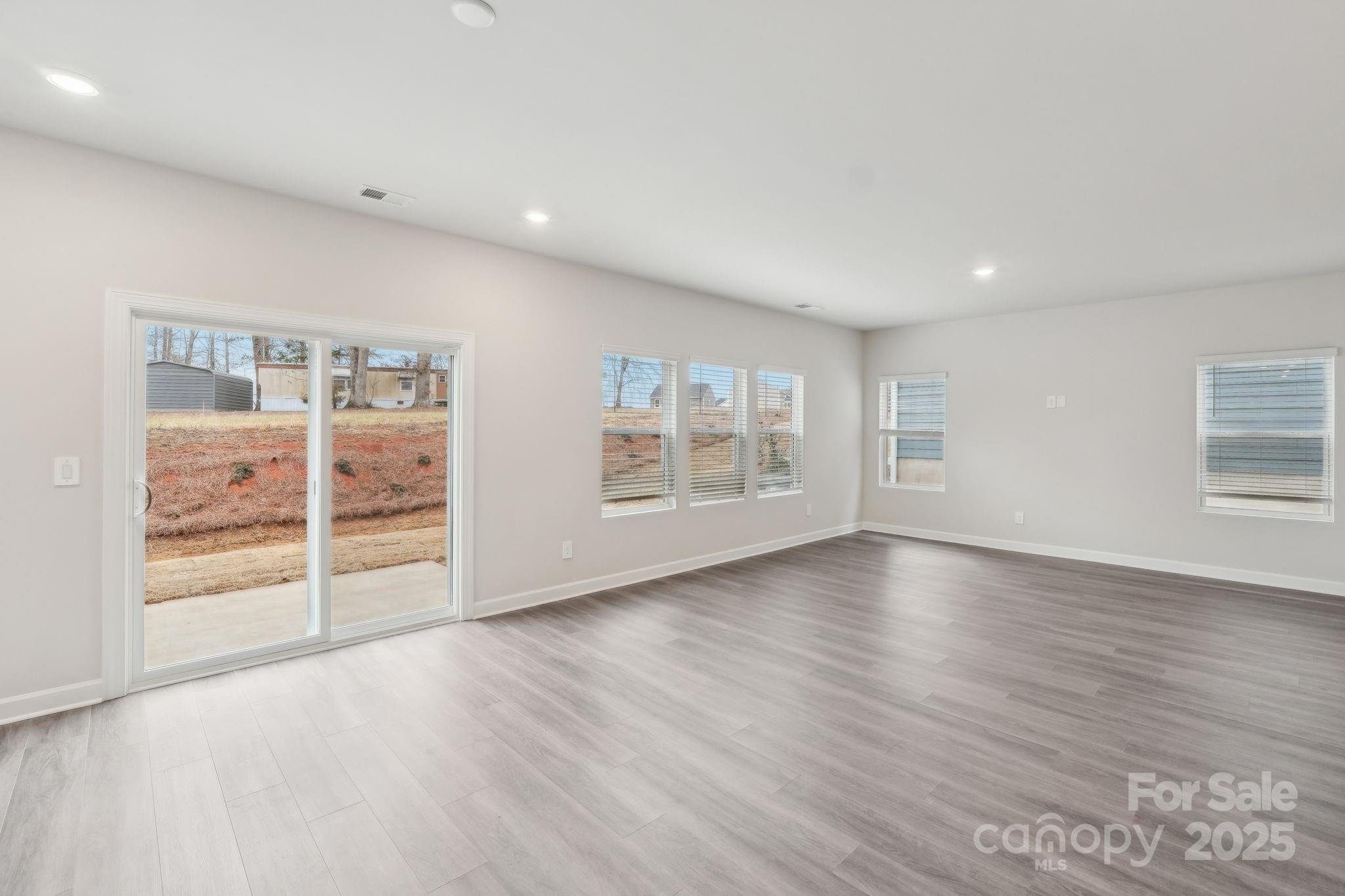 167 Murphy Mdw Road Mocksville, NC 27028 - Photo 7 of 21 an empty room with wooden floor and windows