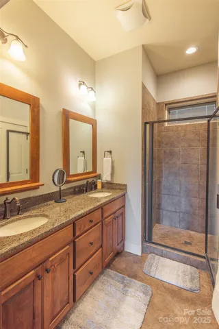 a bathroom with a granite countertop sink mirror and shower