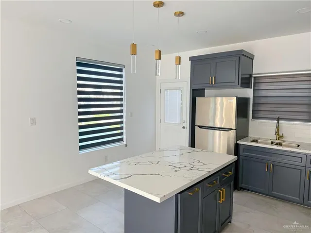 a kitchen with a sink refrigerator and cabinets