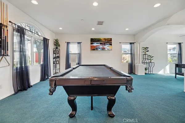 a kitchen with stainless steel appliances a stove top oven a sink a refrigerator and white cabinets