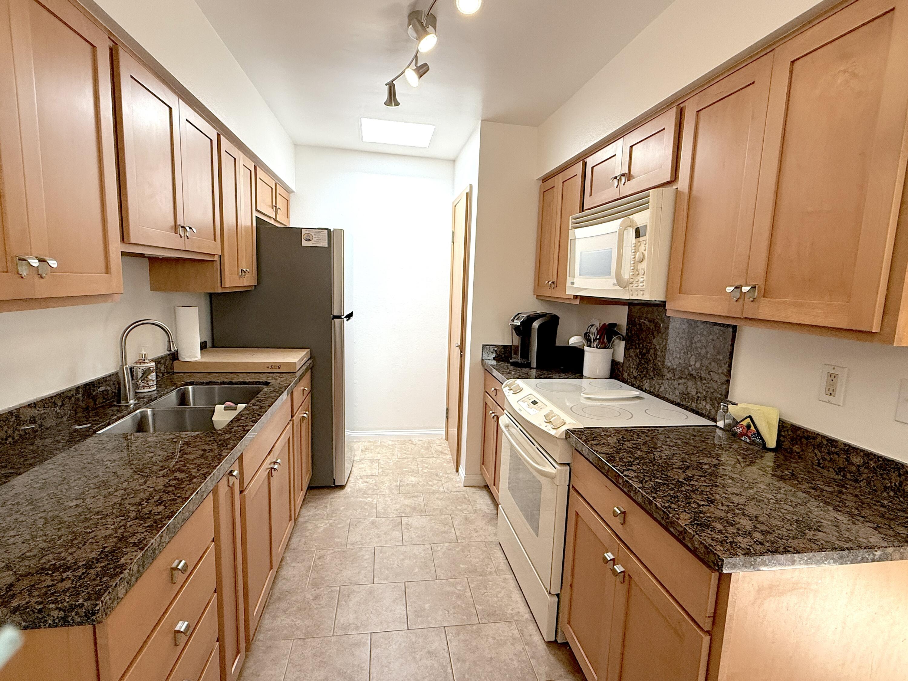 29 Dearborn Place, Unit 10 Goleta, CA 93117 - Photo 4 of 7 a kitchen with stainless steel appliances granite countertop a stove a sink dishwasher and a refrigerator