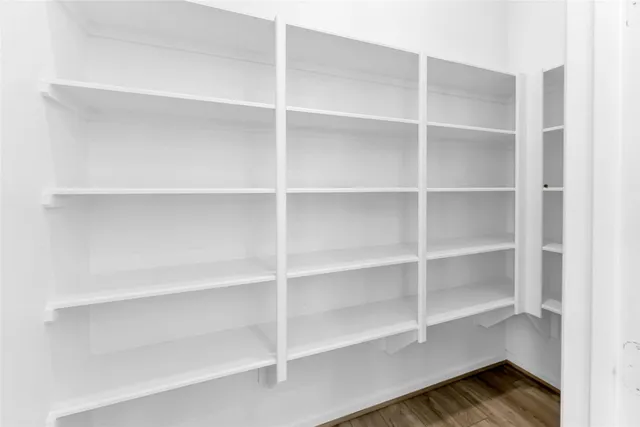 a living room with couches a table and chairs with wooden floor