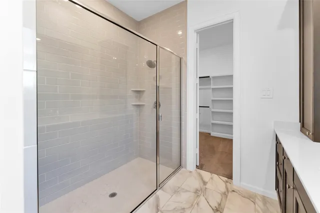 a bathroom with a sink a toilet a shower and a mirror