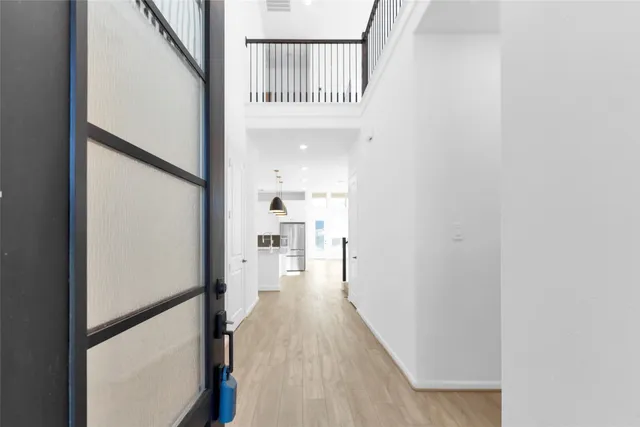 a kitchen with stainless steel appliances granite countertop a sink dishwasher a stove a refrigerator and white cabinets with wooden floor