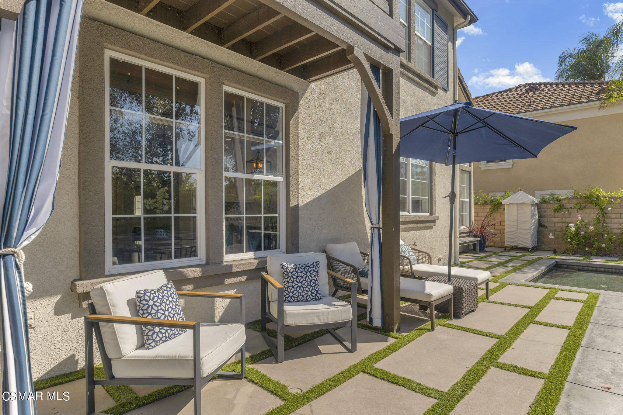 524 Oak Tree Court Simi Valley, CA 93065 - Photo 52 of 61 a view of a patio with a dining table and chairs under an umbrella with a small yard