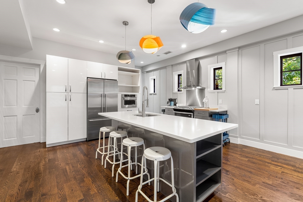 653 East 3rd Street Boston, MA 02127 - Photo 11 of 38 a kitchen with stainless steel appliances kitchen island granite countertop a table chairs and a refrigerator