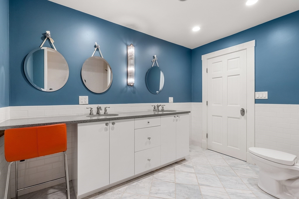 653 East 3rd Street Boston, MA 02127 - Photo 33 of 38 a bathroom with a toilet a double vanity sink and a mirror