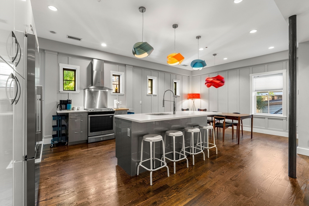 653 East 3rd Street Boston, MA 02127 - Photo 10 of 38 a kitchen with stainless steel appliances kitchen island granite countertop a table and chairs in it