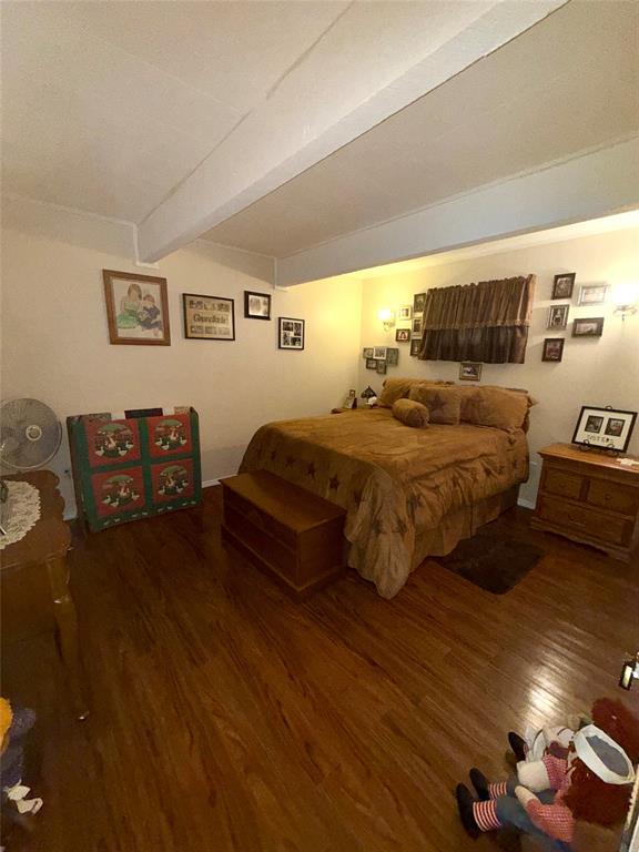 309 Broken Arrow Comanche, TX 76442 - Photo 17 of 33 Bedroom featuring dark wood-type flooring and beam ceiling