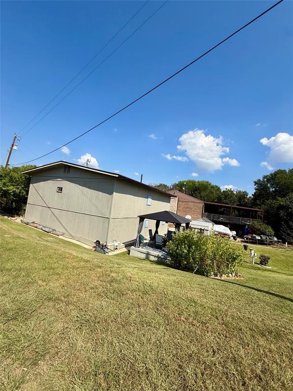 309 Broken Arrow Comanche, TX 76442 - Photo 24 of 33 View of side of home with a gazebo and a lawn