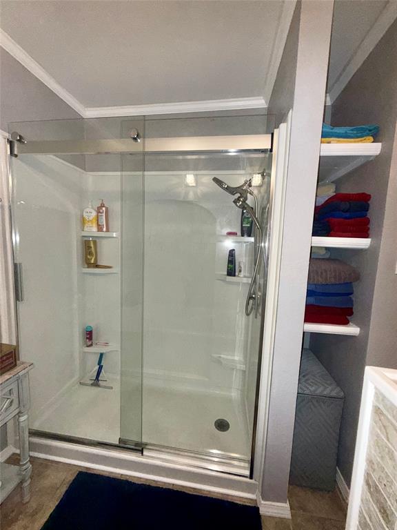309 Broken Arrow Comanche, TX 76442 - Photo 8 of 33 Bathroom featuring crown molding and a stall shower