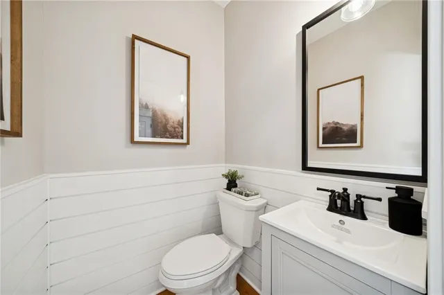 a bathroom with a toilet sink vanity and mirror