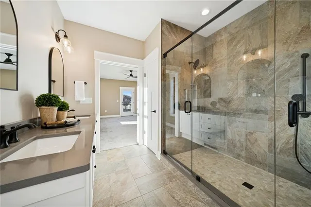 a bathroom with a granite countertop sink mirror and shower