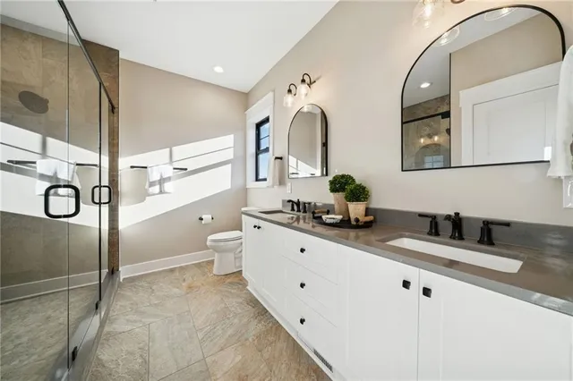 a bathroom with a double vanity sink mirror and toilet