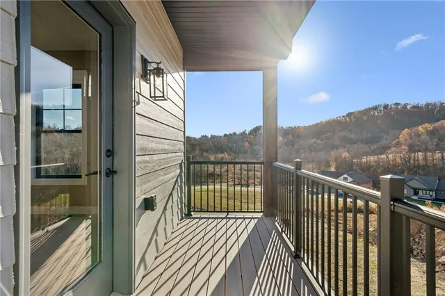 a view of a balcony with wooden floor and floor to ceiling window